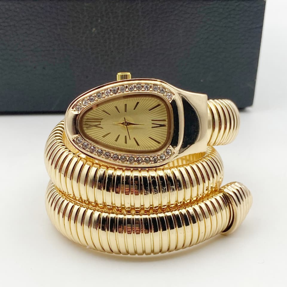 Gold spiral clock with decorative design on a white surface