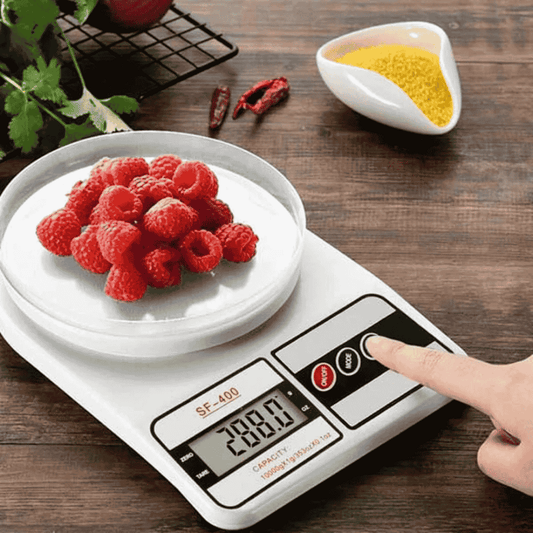 Digital kitchen scale with raspberries on a wooden surface