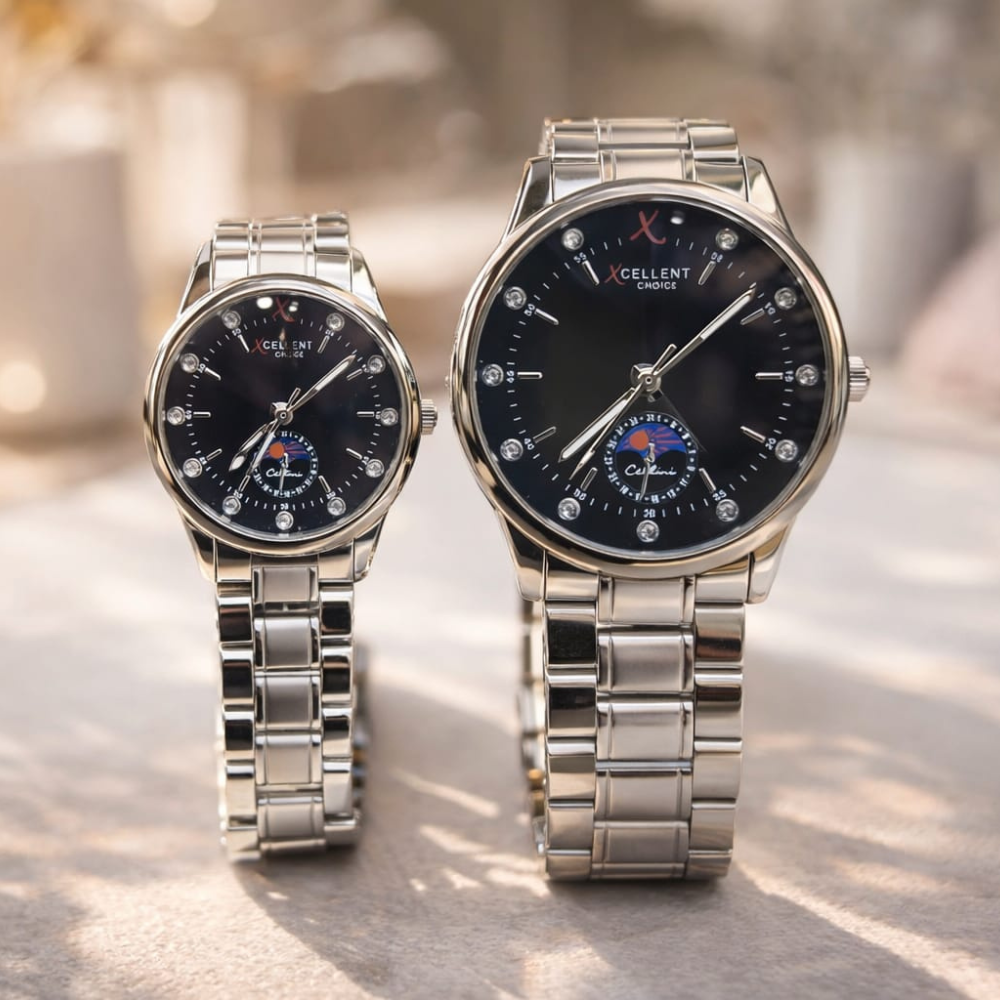 Two silver watches with black faces on a light surface